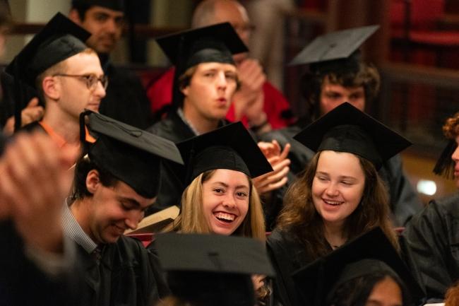 young women smile while wearing graduation reglia