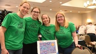 Becca Taylor ’06 and Piece Corps Champs surround a mandala puzzle