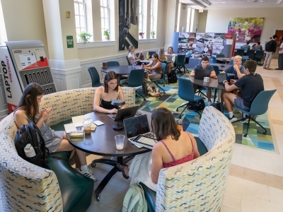 students study in booths and tables in a brightly lit space