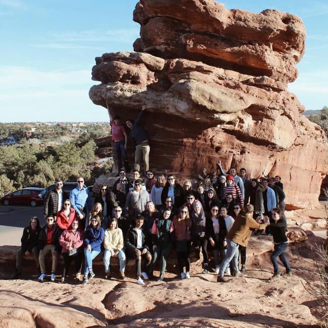 Chorale gathers for picture next to giant boulder in Colorado