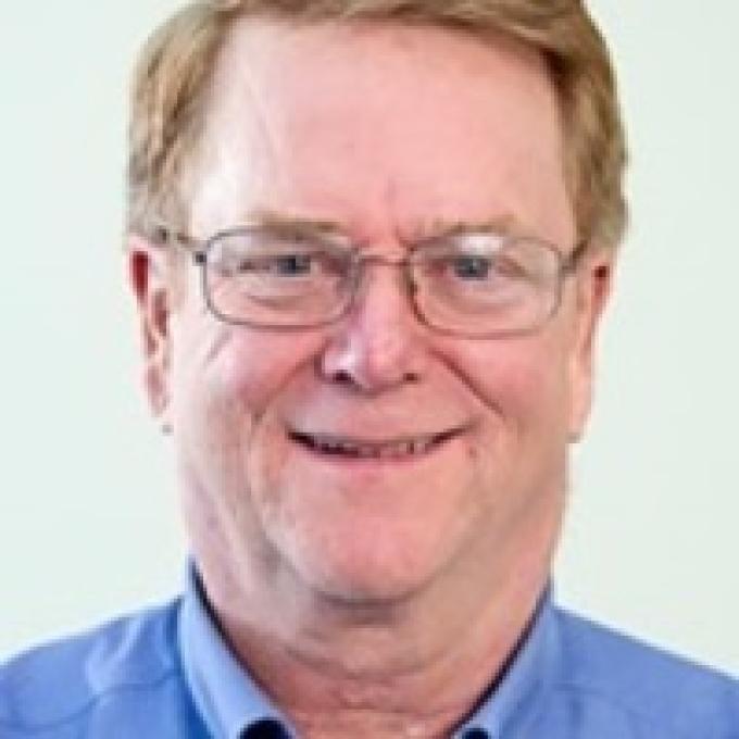 a middle aged white man wearing glasses and blue collar shirt