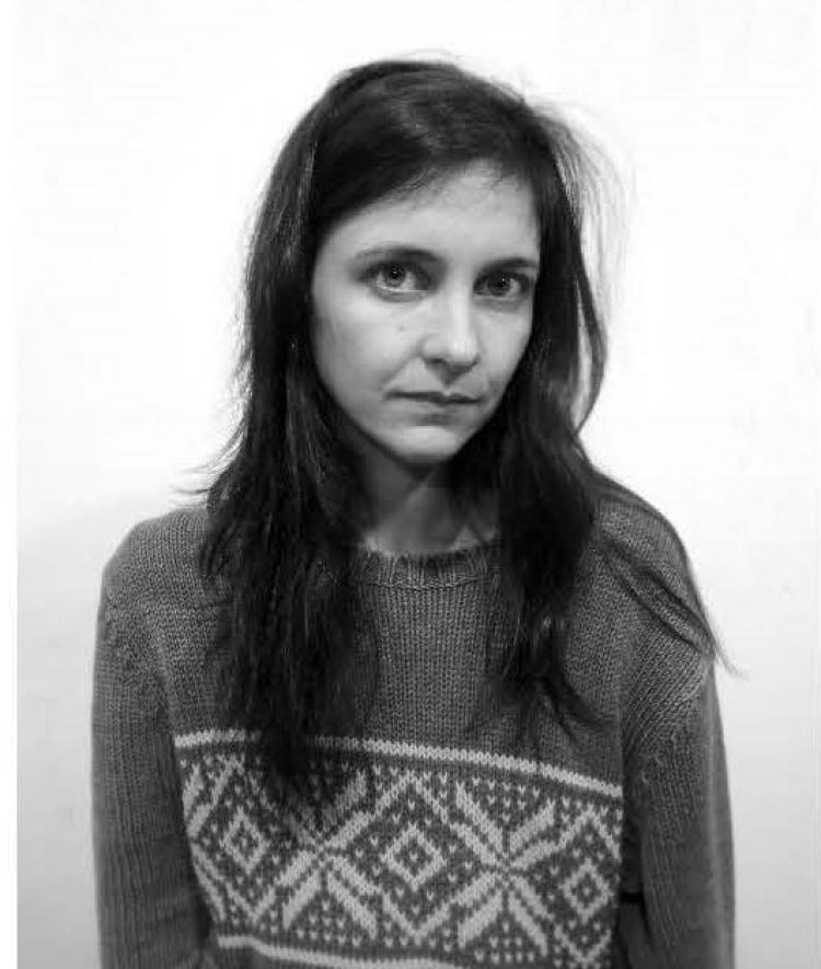 a young woman with brown hair wearing a sweater