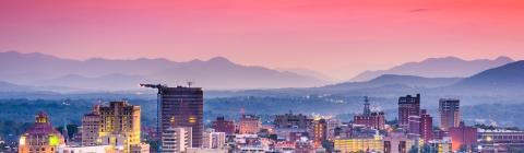 Asheville, NC skyline with mountains and sunset in background