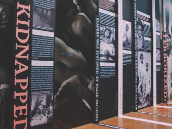 EJI Museum Exhbit with black and white photos of enslaved persons, the word Kidnapped at the front