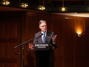 a man speaks into a podium in an auditorium