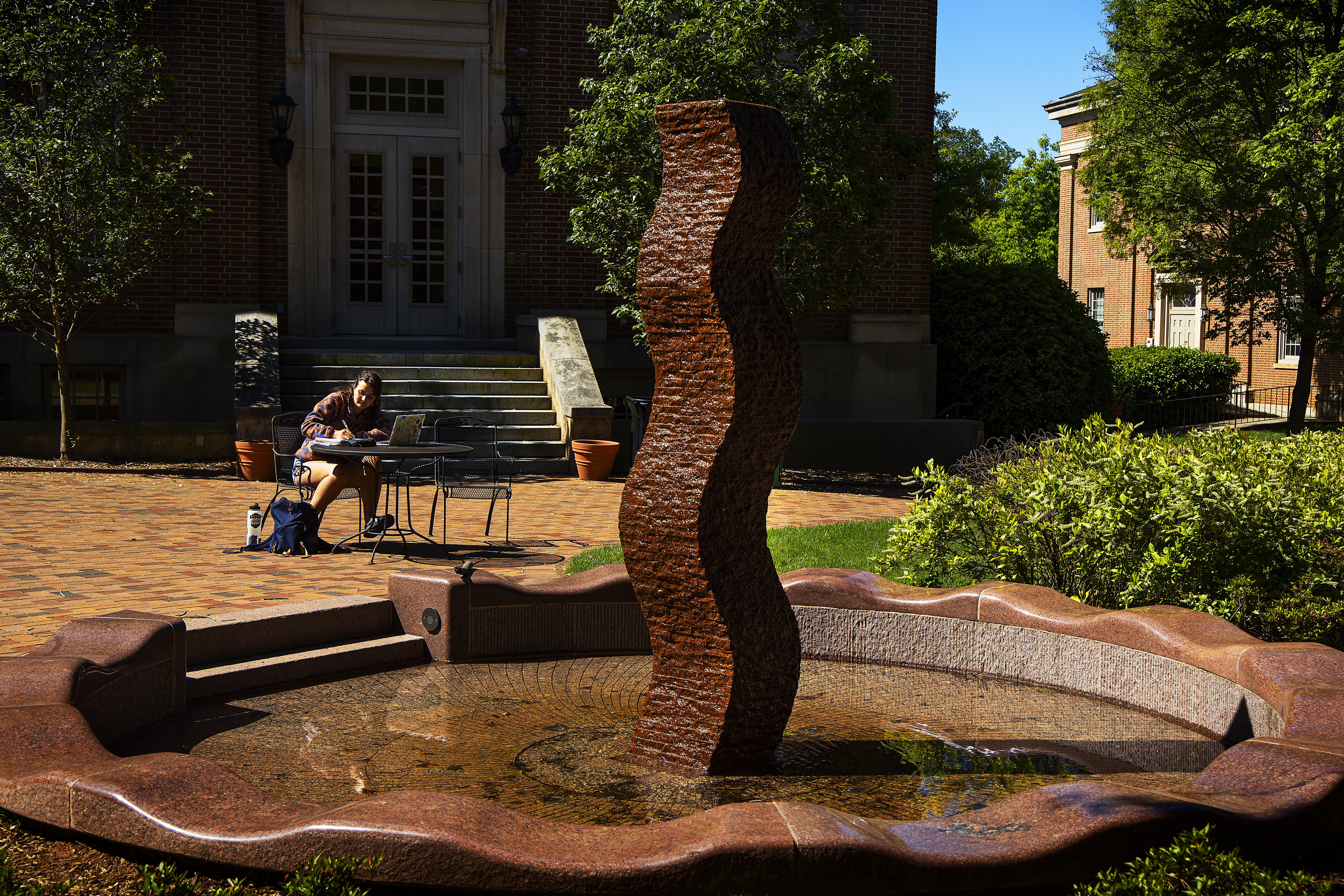 Student studying by art sculpture