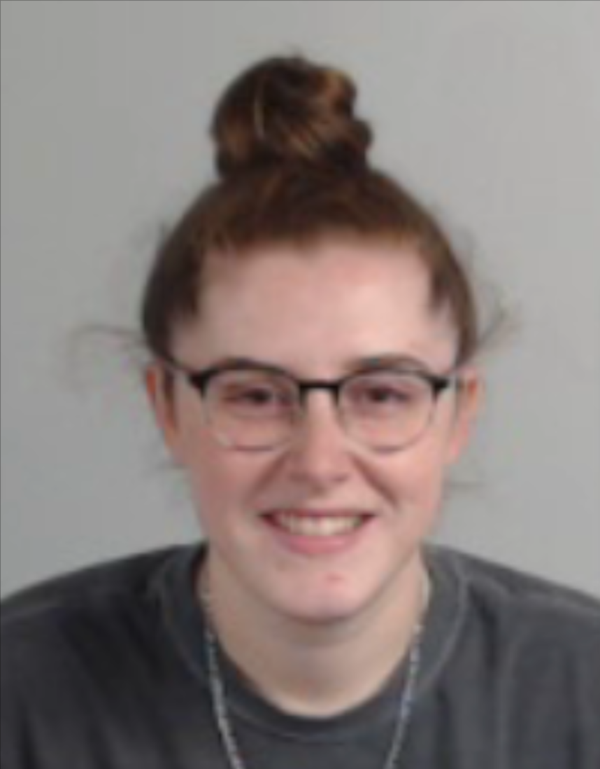 a young white woman wearing glasses with red hair in a bun