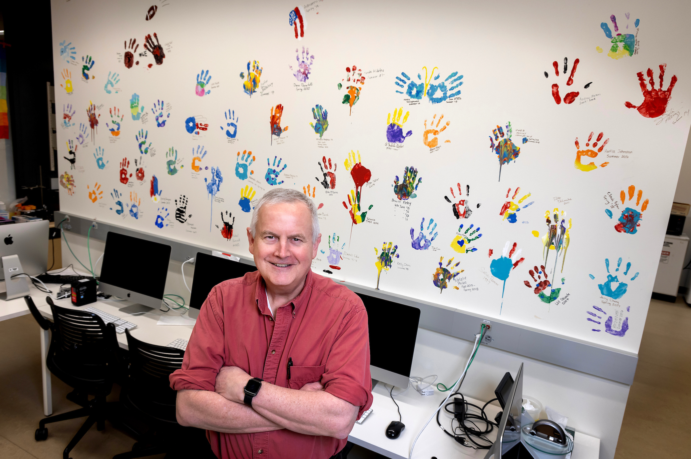 Professor Malcolm Campbell with handprint wall