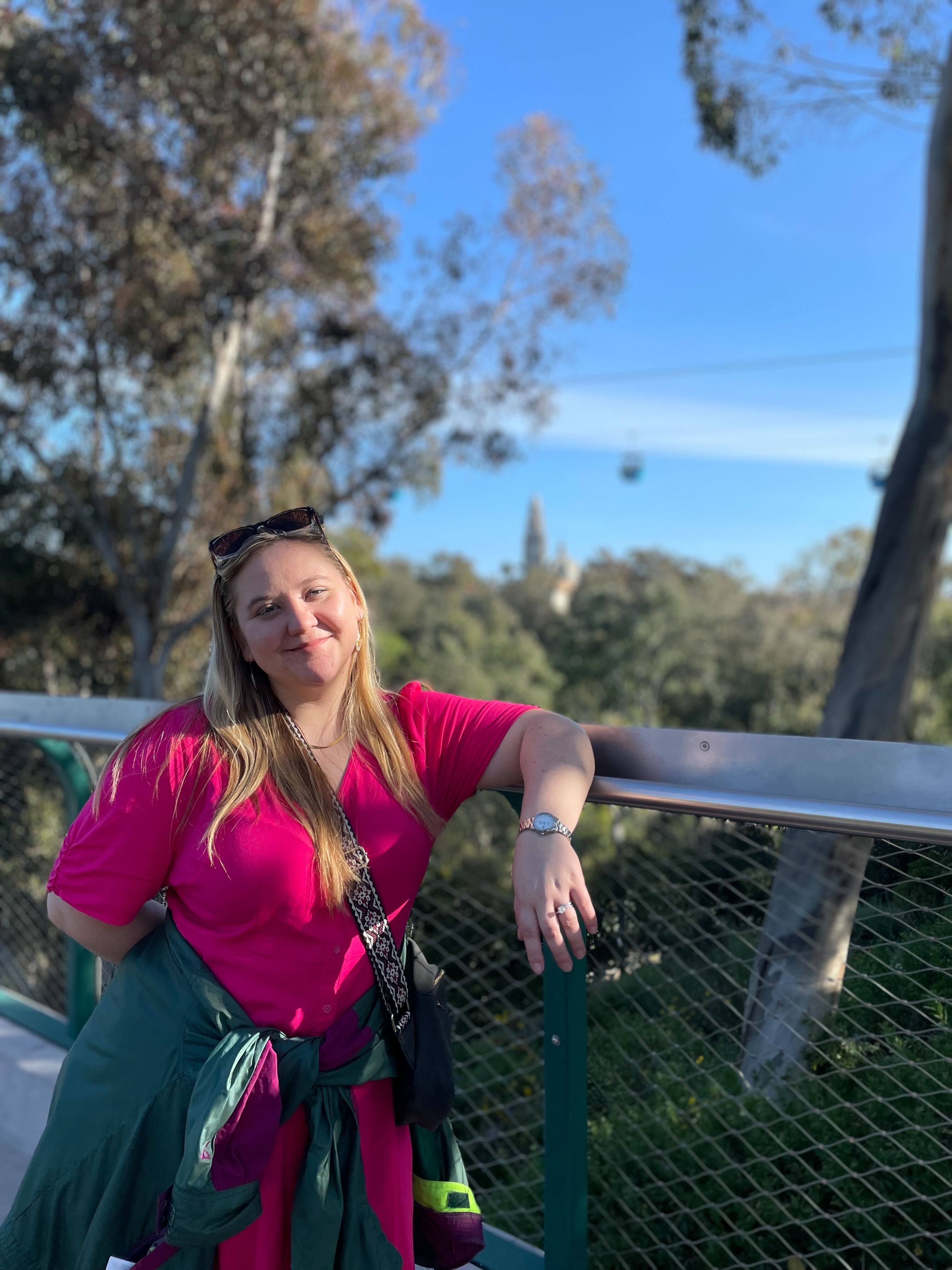 a young white woman stand on an outdoor balcony