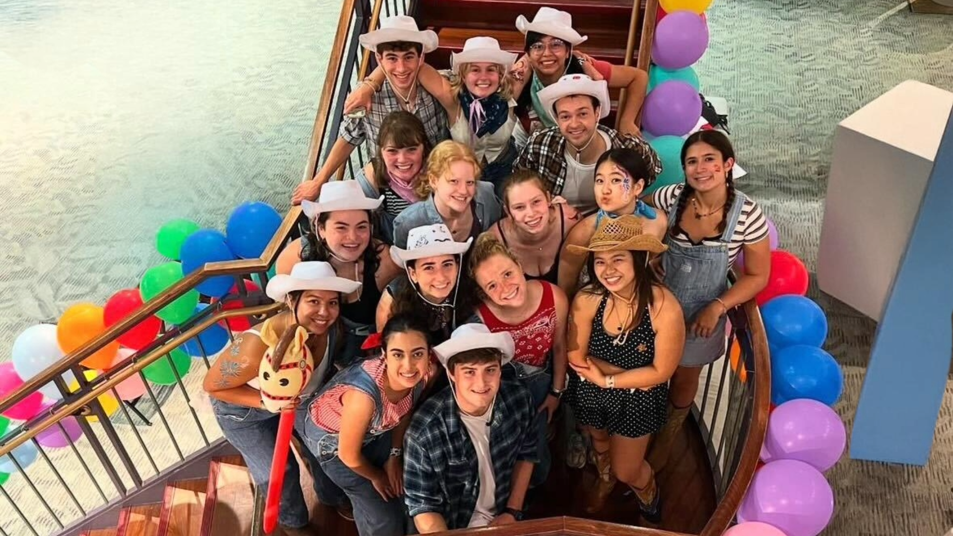 a group of students wearing cowboy hats surrounded by balloons and smiling