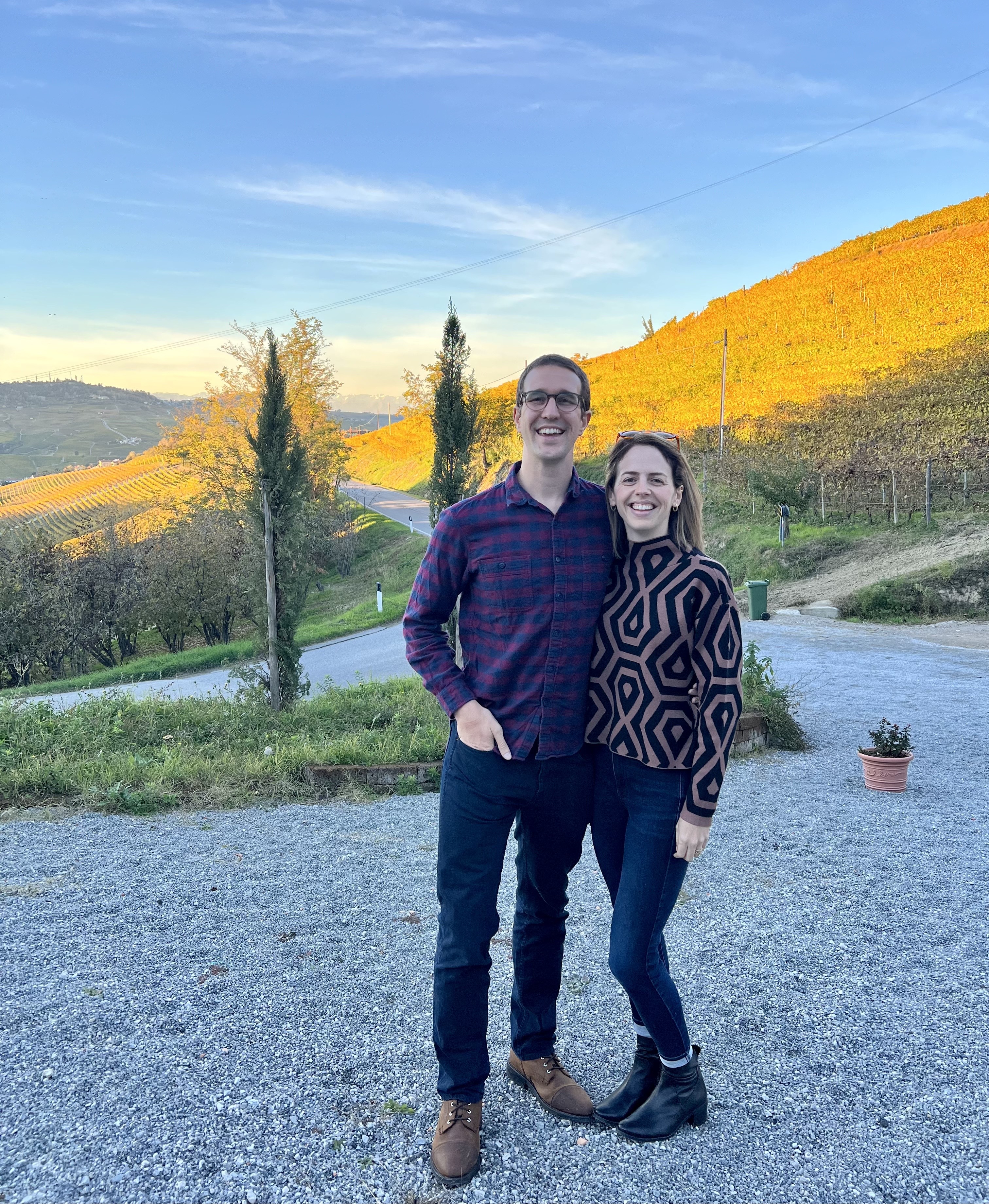 a young couple standing in front of a mountainside