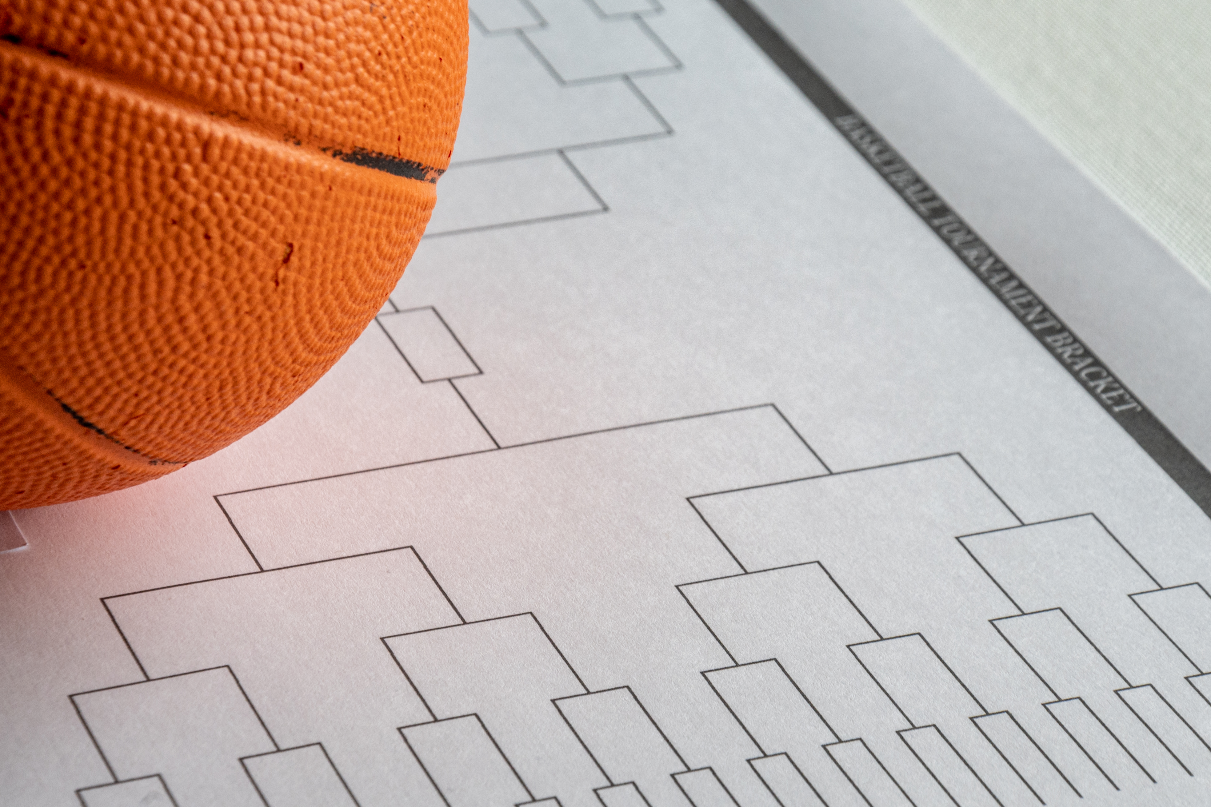 a basketball bracket on a piece of paper with a basketball next to it