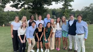 a group of students standing together outside in business casual