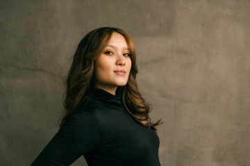 a woman holding her belly in front of a grey background