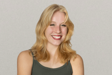 a young white woman with blonde hair wearing a green tank top