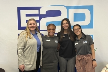 a group of young women standing in front of a wall that reads "E2D"