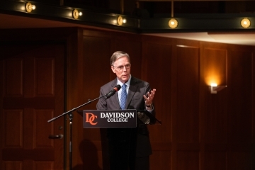 a man speaks into a podium in an auditorium