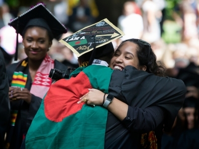 Graduating student hugs another student