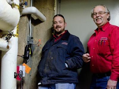 Physical plant employees adjusting equipment