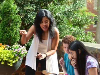 Prof. Esparragoza-Scott talks to two students in outdoor class