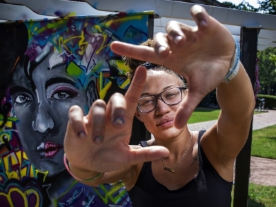 Student makes a square with her fingers, framing her face