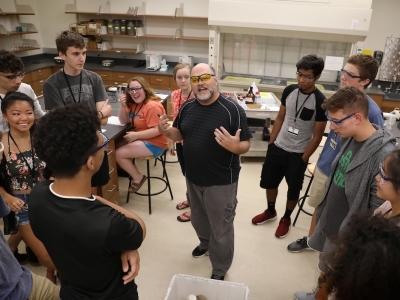 Durwin Striplin in Classroom with Students Gathered Around Him