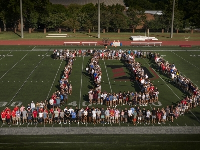 students on football field organized to spell out "D"