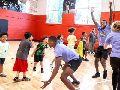 Students and kids play together in a gym