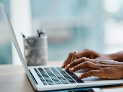 a set of hands on a laptop typing