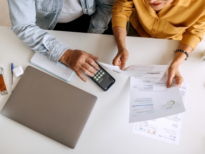 two people sitting at a table with paperwork