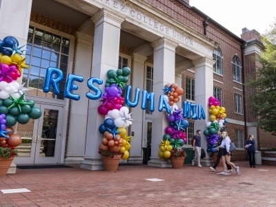 blue balloons spelling "resumania" outside a brick building