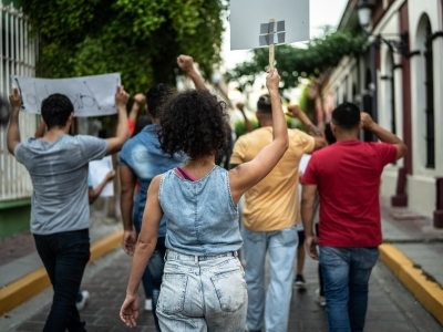 a group of young people holding signs and marching in a street