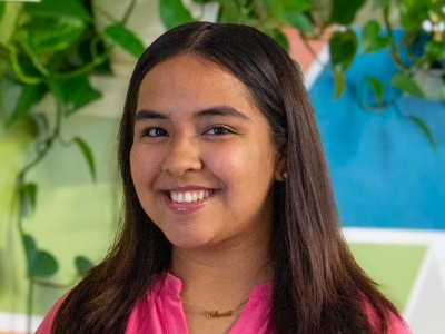 a young woman wearing a pink top with long dark hair