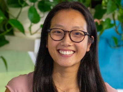 a young Asian woman wearing glasses and smiling