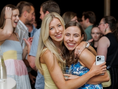 two young women embrace and smile
