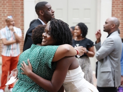 a young Black woman embraces an older woman 