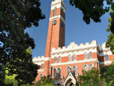 a brick college building surrounded by green trees