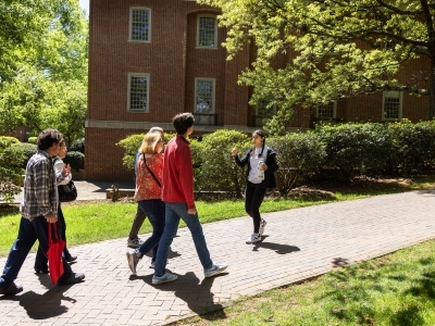 a young woman guides a family around a college campus