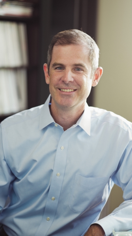 a middle aged white man wearing a light blue collared shirt