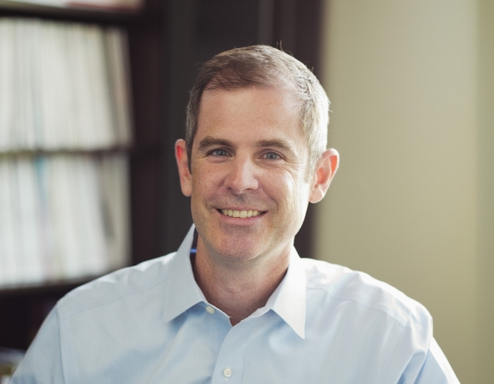 a middle aged white man wearing a light blue collared shirt