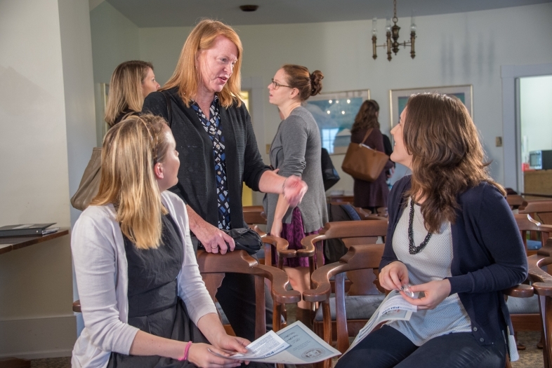 Prof. Boyd talks to two students in Phi Hall during a formal induction ceremony