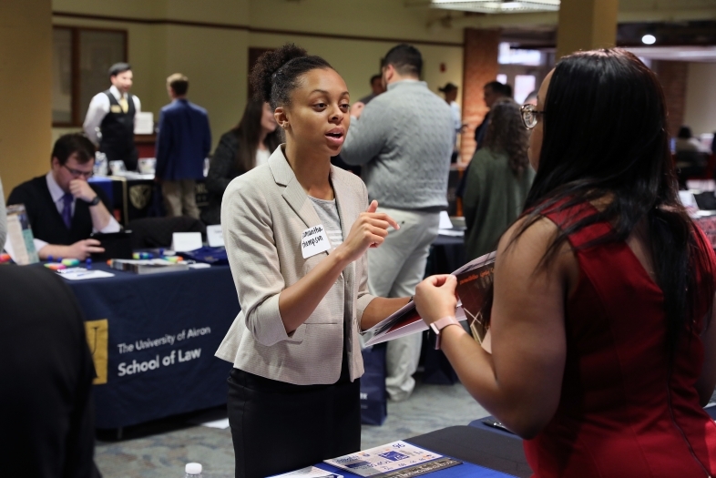 Law school recruiter talks to student at her booth