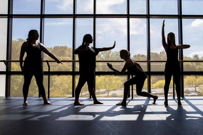 Four dance students pose near a window on a sunny day at one of Davidson's dance studios