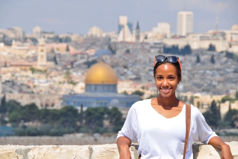 Student stands in front of Amman skyline in Jordan.