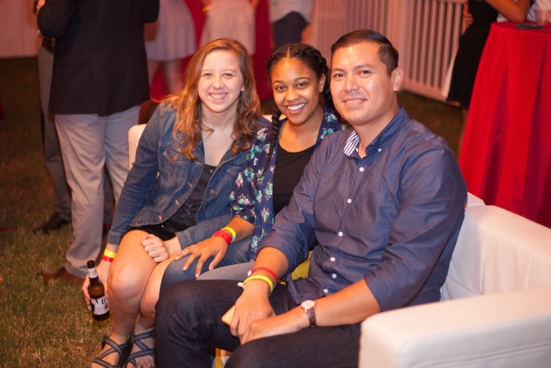 Three alumni sit together at a homecoming event