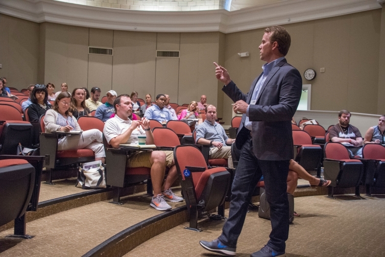 Meeting leader speaks in front of conference attendees in Hance Auditorium