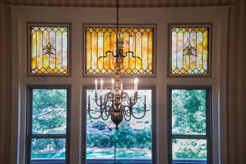 Picture of chandelier and stained glass window inside the Guest House