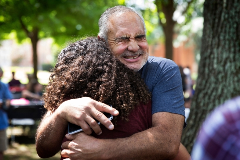 Family member hugs a student while saying goodbye at the Orientation Farewell Picnic on Chambers Lawn