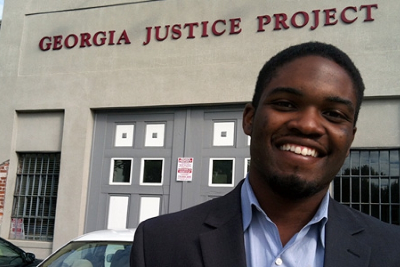 Student fellow stands in front of Georgia Justice Project building