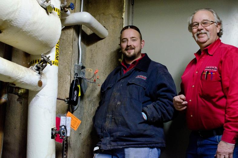 Physical plant employees adjusting equipment